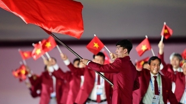 Kình ngư Nguyễn Huy Hoàng cầm cờ cho đoàn thể thao Việt Nam tại khai mạc SEA Games 32