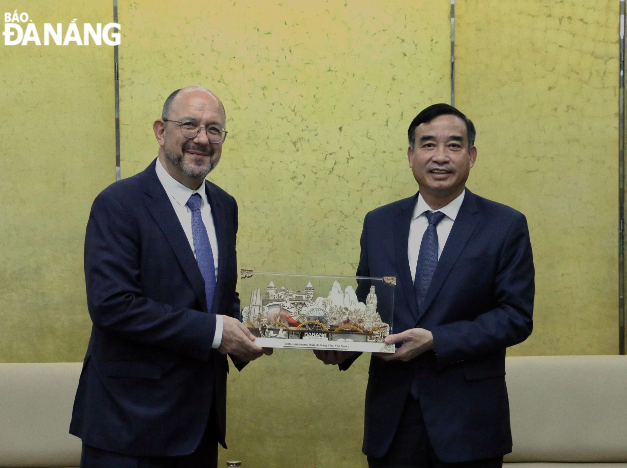 Chủ tịch UBND thành phố Lê Trung Chinh (bên trái) tặng quà lưu niệm cho Đại sứ đặc mệnh toàn quyền Liên bang Thụy Sỹ tại Việt Nam Thomas Gass. Ảnh: T.PHƯƠNG