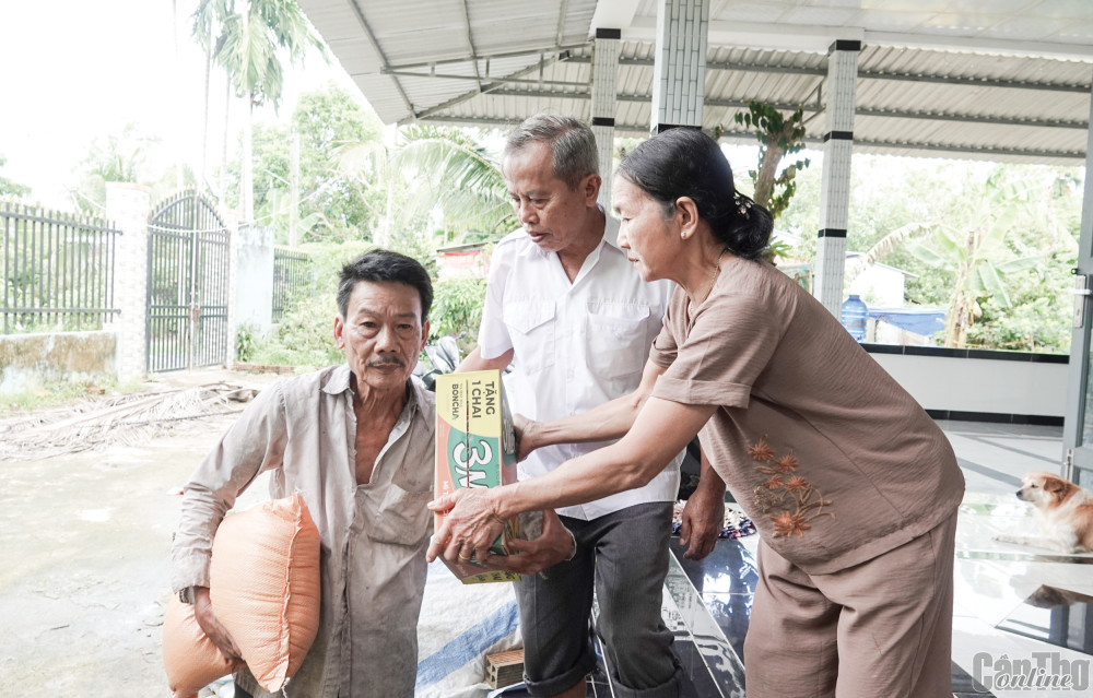 Vợ chồng ông Hai Nùng tặng quà cho bà con.