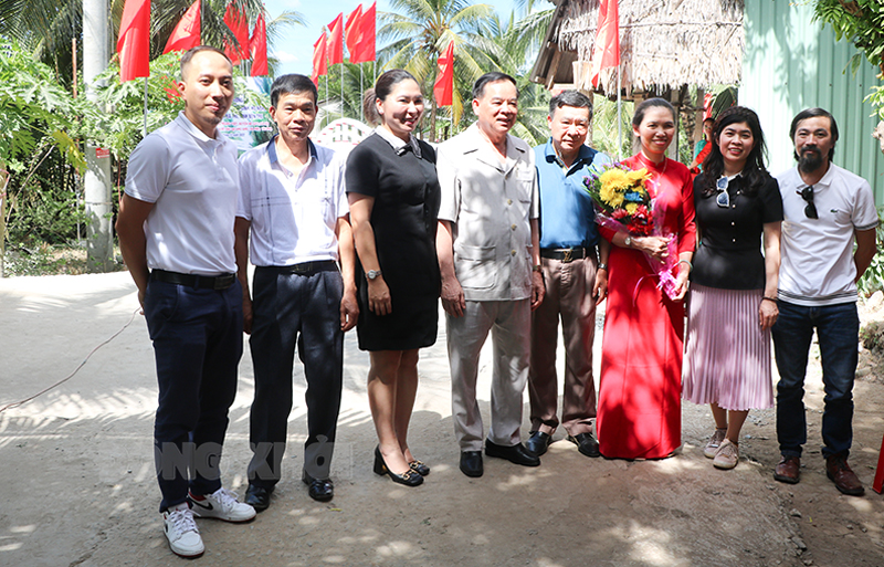 Chủ tịch UBND tỉnh Trần Ngọc Tam trao bằng khen và hoa cho gia đình ông Nguyễn Hữu Thọ (thứ 4 từ phải qua).