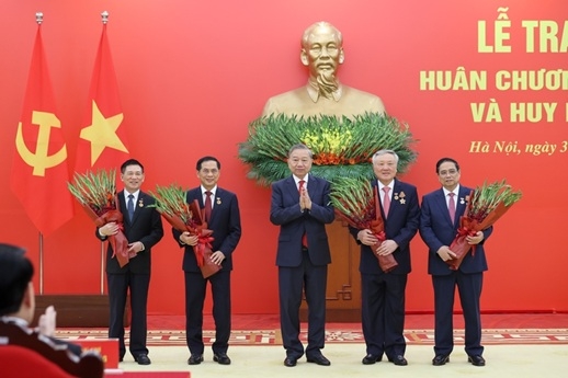 Tổng Bí thư Tô Lâm tặng hoa chúc mừng các đồng chí được nhận Huy hiệu Đảng - Ảnh: VGP/Nhật Bắc