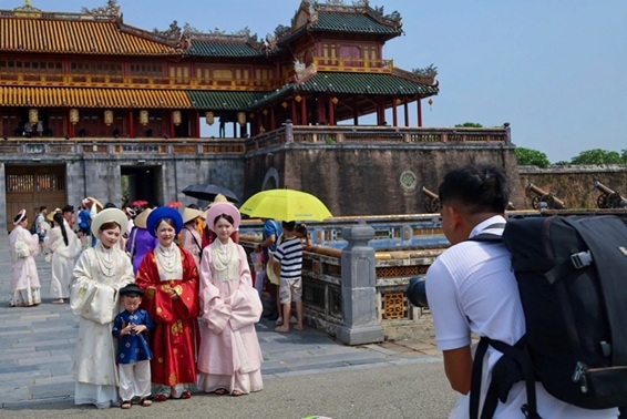 Du khách tham quan Đại Nội Huế và trải nghiệm trang phục áo dài. Ảnh: Đình Hoàng 