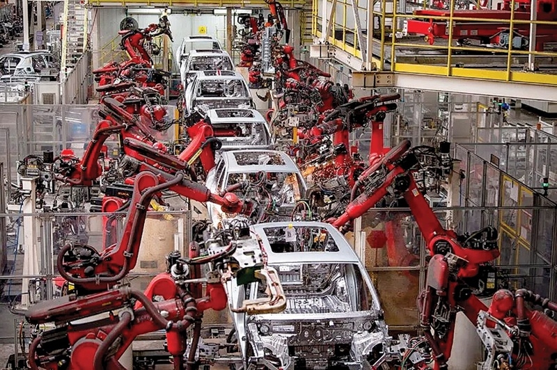 Các cánh tay robot điện đang hoạt động trên dây chuyền lắp ráp xe điện tại Trung Quốc